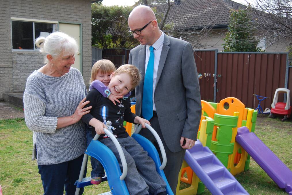 Family day care operator Sharon Taylor, with two of her charges  Harriet (2) and Tommy Bowen (5)  and the mayor, Mark Greenhill in the Taylors' backyard in Mt Riverview.