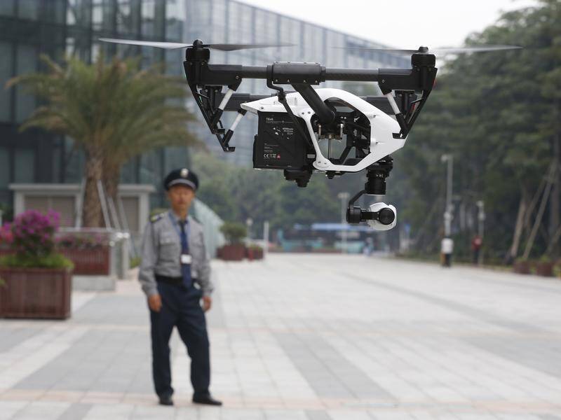 FILE: A man watches a 2014 demonstration of a DJI Technology Co Inspire 1 drone in Shenzhen, China.
