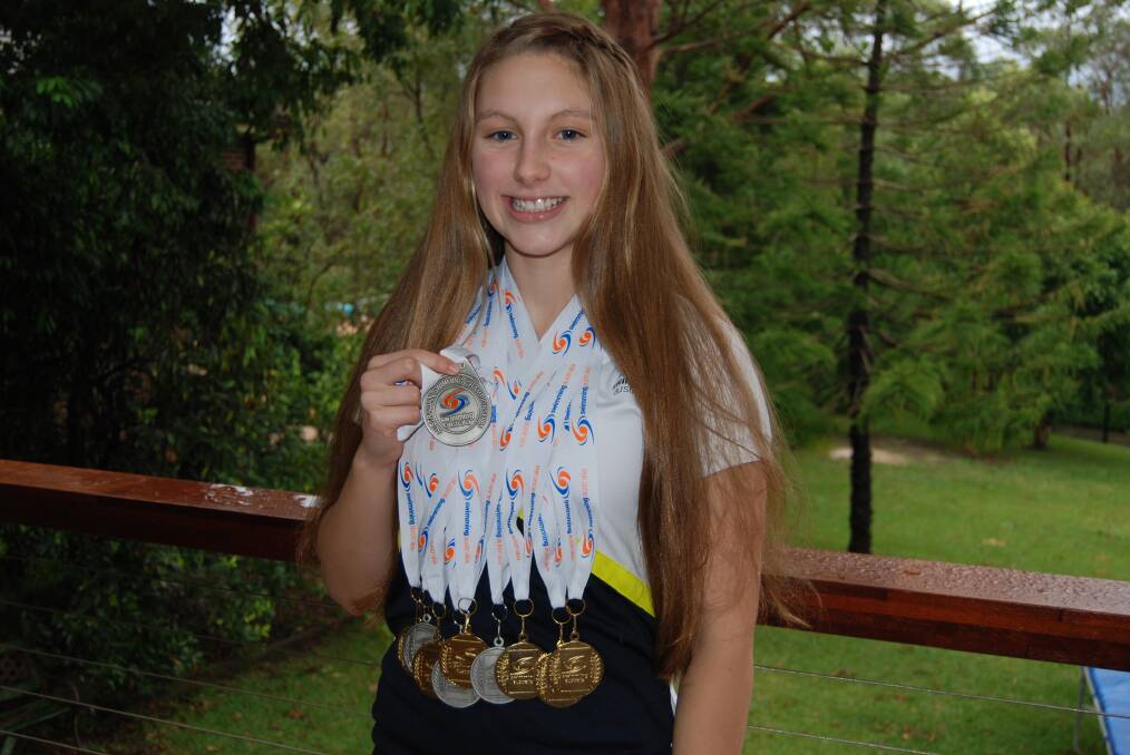 Jenna Jones with her age championship medals around her neck, and holding the silver she won at the national titles.