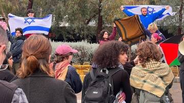 Students have brandished Israel flags at a pro-Palestine protest at Monash University in Melbourne. (Holly Hales/AAP PHOTOS)
