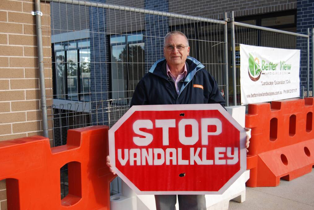 Clr Chris Van der Kley with one of the signs made during negotiations about the re-creation of Lawson. 