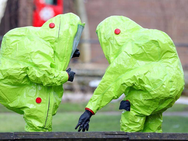 Personnel in hazmat suits inspect the bench where a former Russian spy and his wife were found.