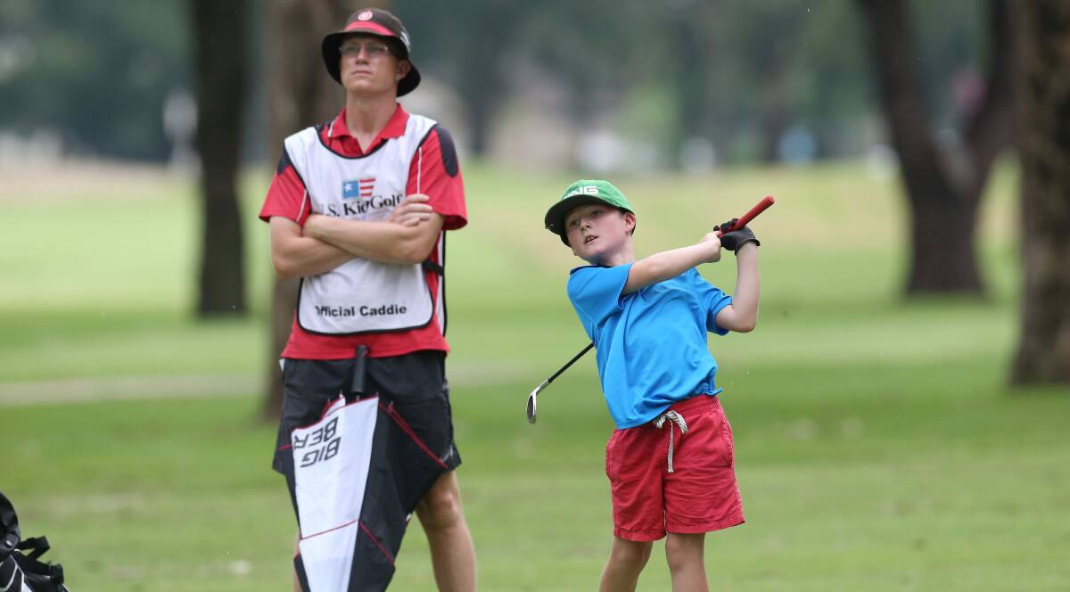 In form: Harry Daniels, 8, with his caddy, dad Tom, at Richmond for the U.S. Kids Golf tournament. Photo: Geoff Jones
