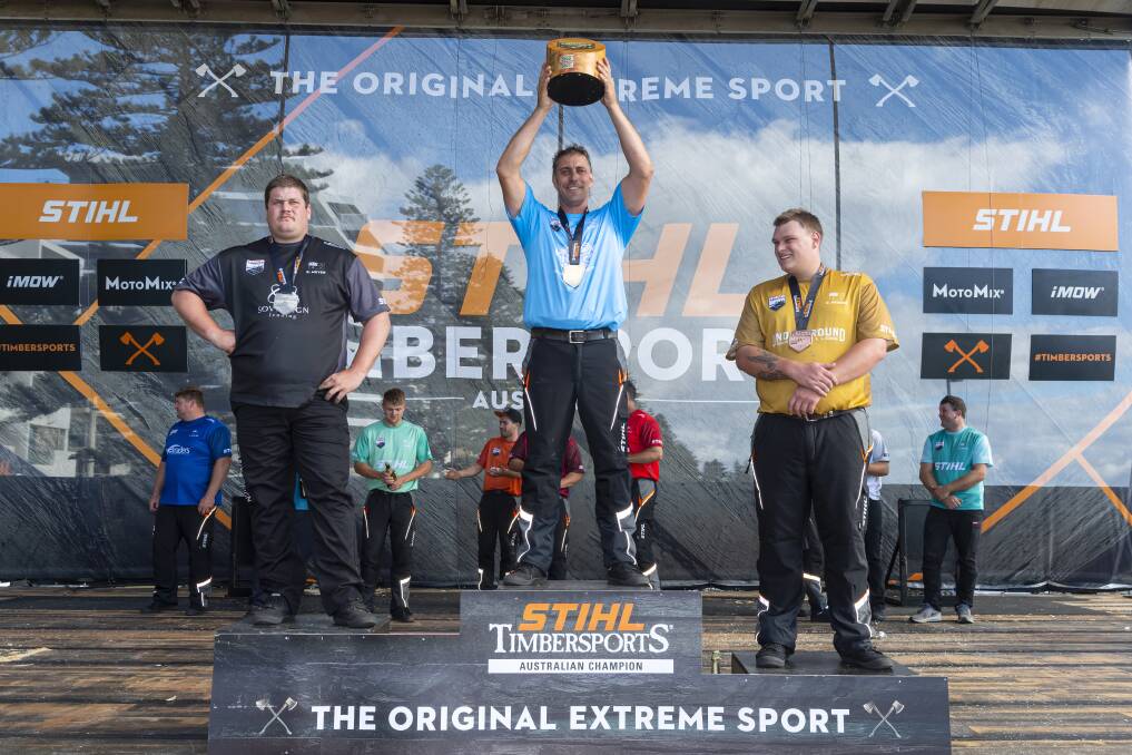 VICTORIOUS: Former Blackheath axeman, now South Bowenfels based Brad De Losa (middle) holds up the 2022 Stihl Timbersports Australian Trophy at Glenelg Beach, South Australia. Picture: SUPPLIED