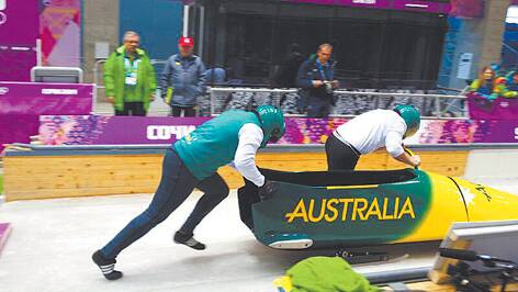 Former Glenbrook resident Dustin MacPherson pushes the rear of Australia's sled during a training session last week at the Sanki Sliding Centre in Sochi, Russia. He was selected as the reserve athlete for the four-man bobsleigh team.