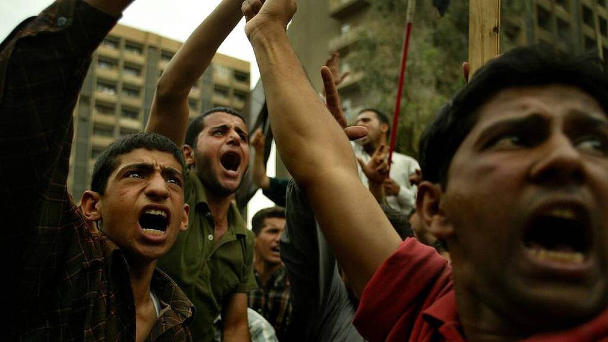Young Iraqi men gather in the streets of Baghdad, protesting the invasion. Baghdad, Iraq. 22nd April 2003. Photo: Kate Geraghty