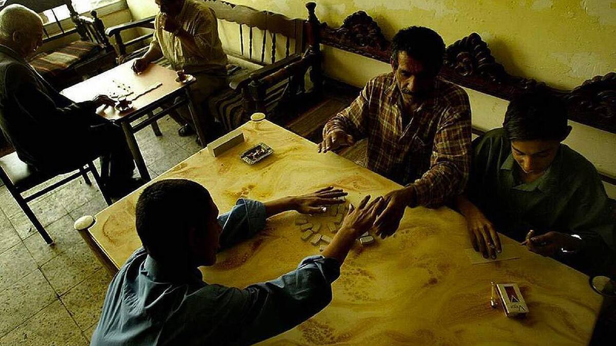 Iraqi men and their sons spend their time in the Chi houses playing draughts and backgammon until jobs are a possibility and the schools start again. Anu Naus district, Baghdad, Iraq. 22 April, 2003. Photo: Kate Geraghty