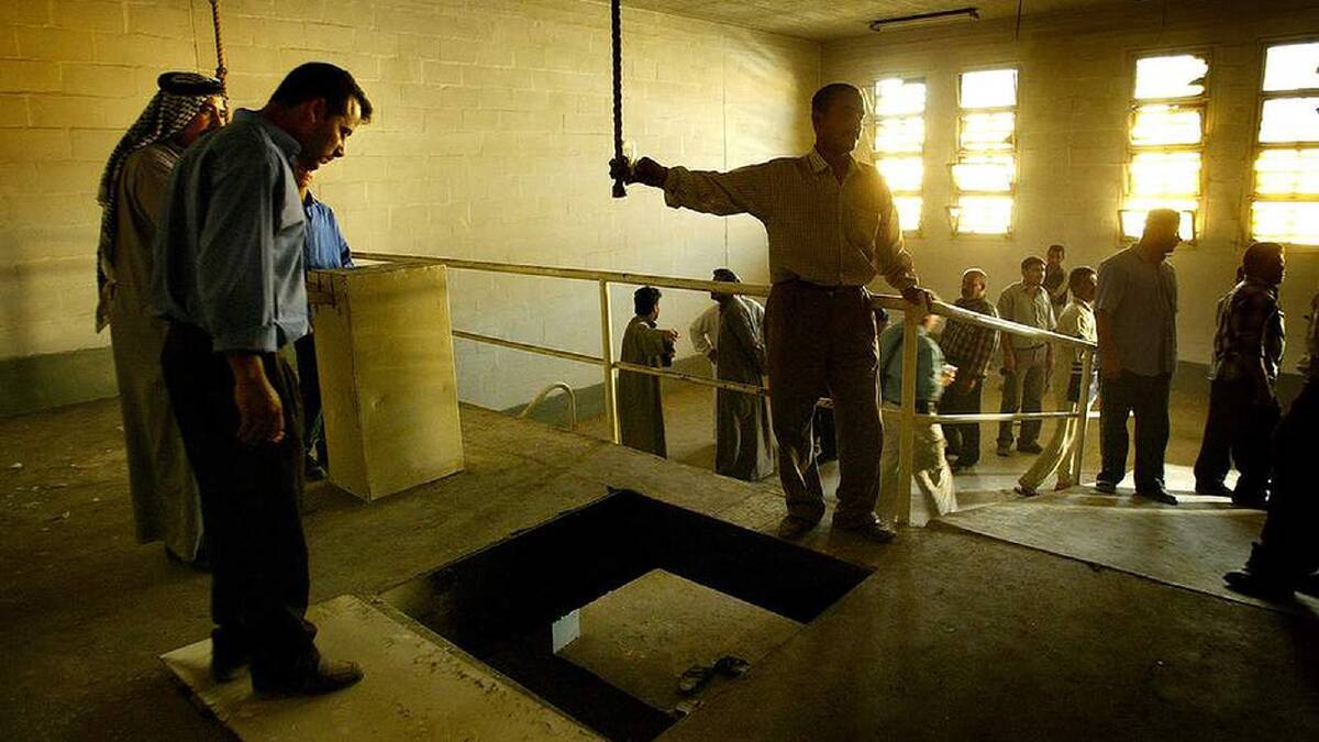 Men gather in the hanging chamber in the infamous Abu Ghraib prison in the days following the fall of Baghdad, searching for any clues to the where abouts of missing loved ones. Baghdad, Iraq. March 2003. Photo: Kate Geraghty