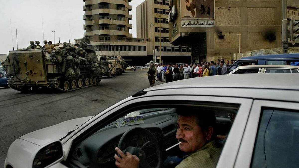 Iraqi drivers wait patiently as a US military convoy drives through the streets of Baghdad. 22nd April, 2003. Photo: Kate Geraghty