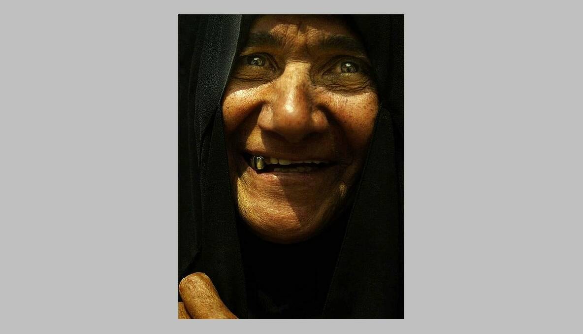 Abu Sara smiles for her first portrait in over 12 years, pictures she states is not for the small people. Baghdad, Iraq. 23rd April, 2003. Photo: Kate Geraghty